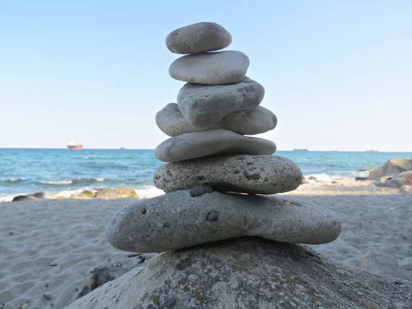 Зенітний камінь стоїть біля моря. Гармонія, баланс і концепція простоти. Пейзажна галька, скульптура дзен, пляжний кам'яний двір . — стокове фото