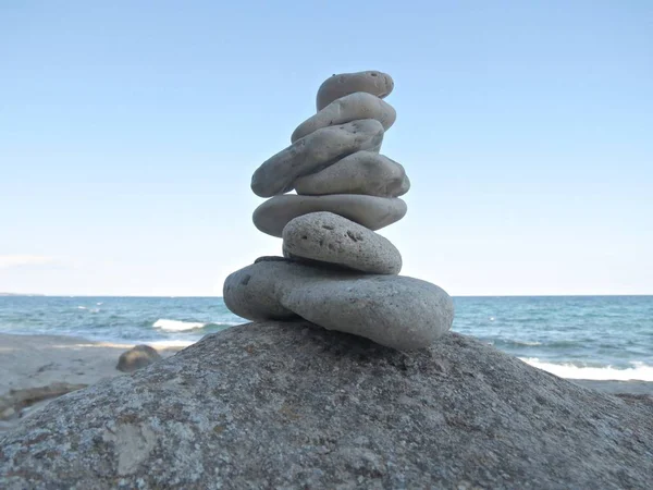 Concepto de armonía, equilibrio y simplicidad. Una torre de piedra sobre el fondo marino. guijarros aplomo simple, escultura zen roca . — Foto de Stock