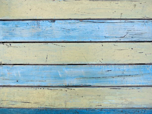 Nuhruinen maalattu puinen rakenne, tausta ja taustakuva - sininen ja keltainen. Lähikuva seinän valmistettu puusta lankkuja . — kuvapankkivalokuva