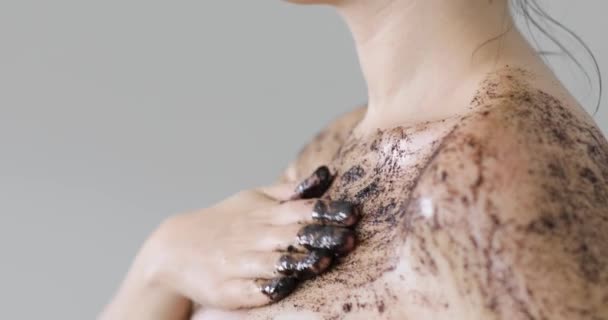 Kvinna tillämpar ekologisk kaffe skrubb på axeln och bröstet, närbild sida vy. — Stockvideo