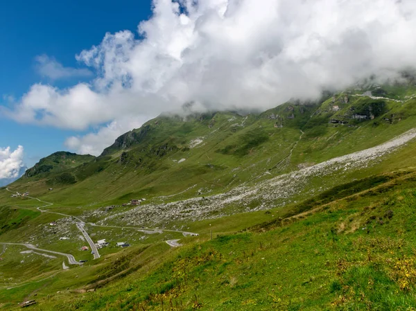 high mountain peaks covered in mystic fog on a scenic day in summer, Switzerland