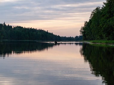 sup tahtasından alınan resim, gölde akşam renkleri, koyu ağaç siluetleri, Vaidava Gölü, Letonya