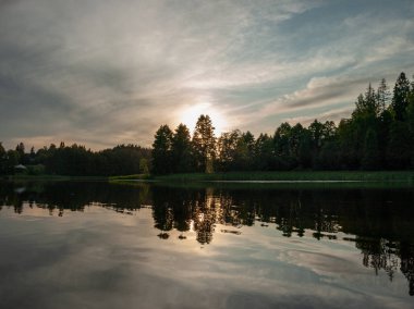 sup tahtasından alınan resim, gölde akşam renkleri, koyu ağaç siluetleri, Vaidava Gölü, Letonya