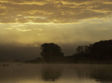 Teknelerle nehirde sabahın erken saatlerinde. büyüleyici gündoğumu, letonya