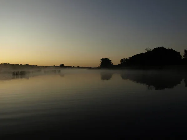 Туманный Оранжевый Восход Солнца Реке Горящее Небо Отражается Спокойной Воде — стоковое фото