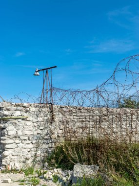 Hapishane çitinin üzerine monte edilmiş dikenli tel parçası, Rummu ocağı, Estonya