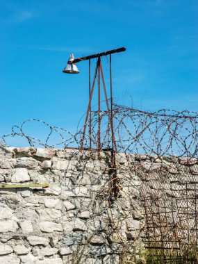 Hapishane çitinin üzerine monte edilmiş dikenli tel parçası, Rummu ocağı, Estonya