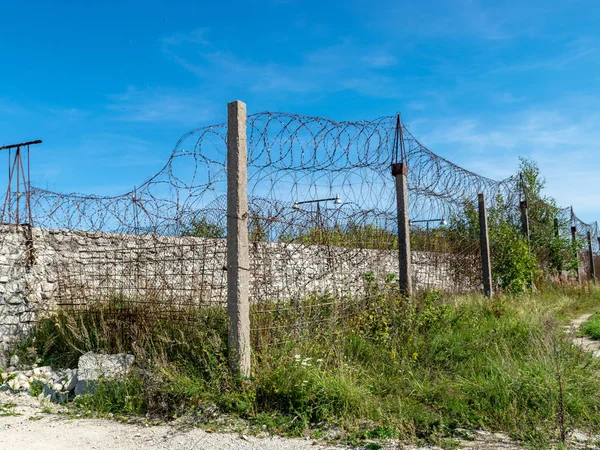 Hapishane çitinin üzerine monte edilmiş dikenli tel parçası, Rummu ocağı, Estonya