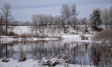 güzel nehir kış günü görünümü, karlı ağaçlar, birçok bulutlar, güzel yansımaları, sakin nehir suyu, Gauja nehri, Valmiera, Letonya