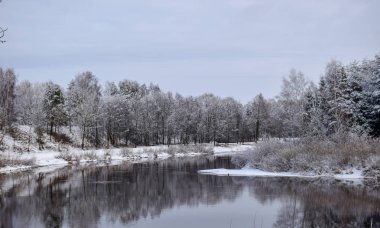 güzel nehir kış günü görünümü, karlı ağaçlar, birçok bulutlar, güzel yansımaları, sakin nehir suyu, Gauja nehri, Valmiera, Letonya