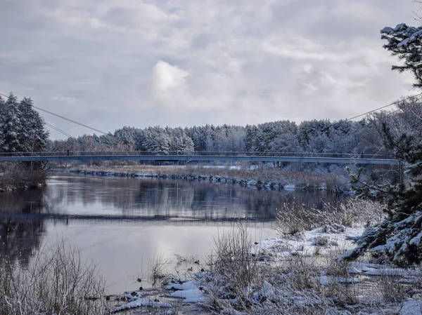 view of beautiful river winter day, snowy trees, many clouds, beautiful reflections, calm river water, Gauja river, Valmiera, Latvia