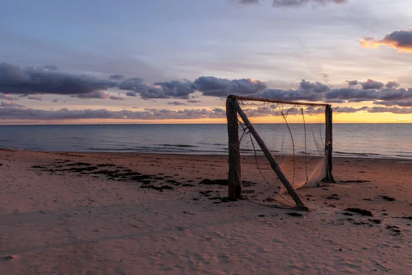 beautiful photography at sunset by the sea, silhouette of a football goal on the beach, silhouette, beautiful and colorful sky