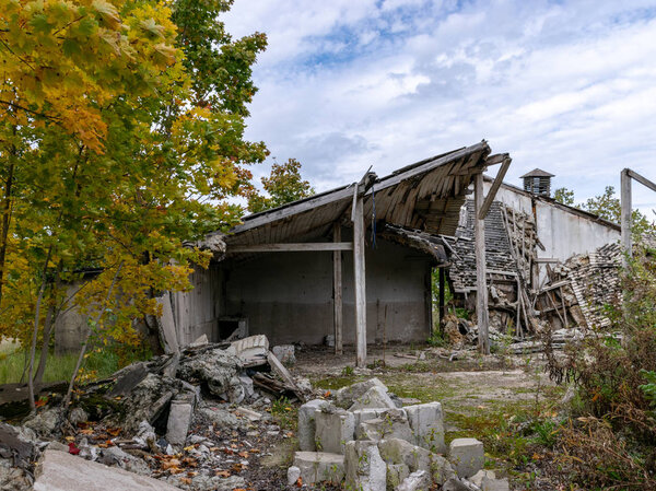 Autumn landscape with demolition of the building, destroyed building, surrounded by colorful trees