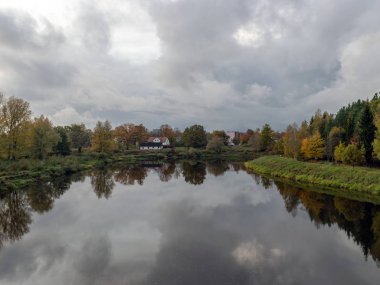 Göl manzarası, güzel renkli ağaçlar, suda yansımalar.