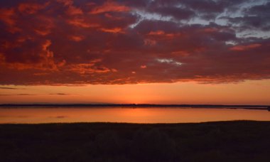 Burtnieku Gölü 'nün üzerinde güzel, dingin, renkli günbatımı ve Letonya' nın göl yansımaları. 