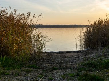 Gün batımında gölün akşam manzarası, sakin ve sakin bir su.