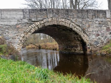 Güzel taş kemerli köprü küçük nehrin üzerinde, sonbahar günü