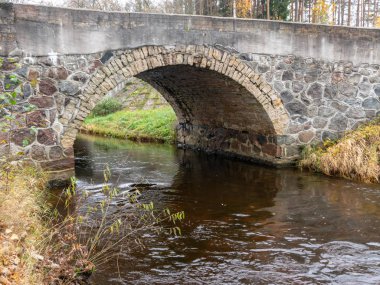 Güzel taş kemerli köprü küçük nehrin üzerinde, sonbahar günü