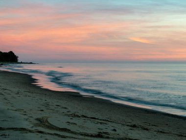 Odakları çözülmüş manzara denizin üzerinde güzel dramatik altın gökyüzü, gün batımında yansıma, uzun süre maruz kalma 