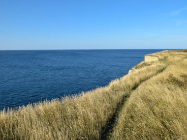 Kayalık uçurumlu deniz manzarası, mavi deniz ve gökyüzü