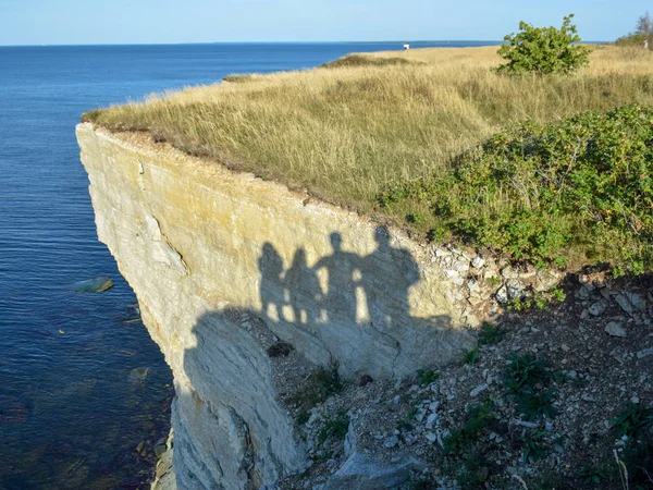 abstract picture with human shadows on a rock wall, seashore