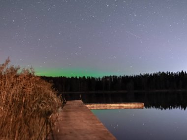 Güzel renkli bir gece gökyüzü ve yıldızlı manzara, gölün yansıması, bulanık siyah zemin