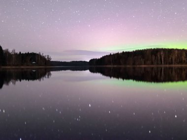 Güzel renkli bir gece gökyüzü ve yıldızlı manzara, gölün yansıması, bulanık siyah zemin