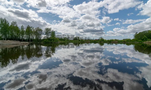 nice calm scene of beautiful sky with cumulus clouds reflection on the lake