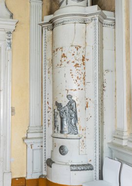 Eski bir şato odasındaki eski beyaz fayanslı bir resim.