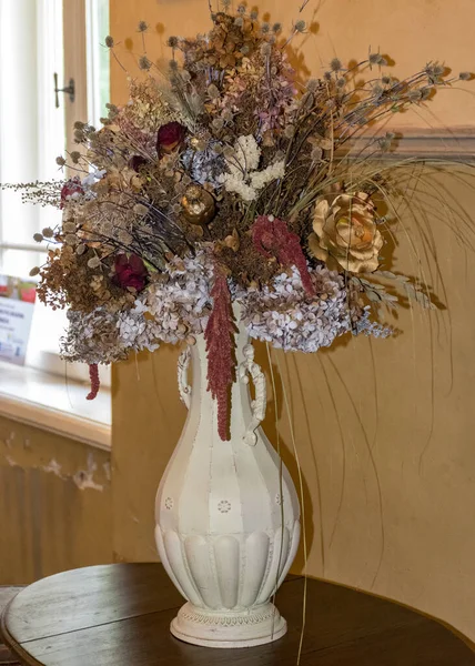 picture with an old vase and dried flowers in an old castle room