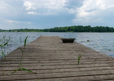 Tahta bir köprü dokusuna sahip yaz manzarası, gölde tahta bir yaya köprüsü.