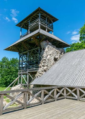 Taş kale kalıntıları ve ahşap kulesi olan yaz manzarası, Limbazi, Letonya
