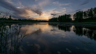 Gölün üzerinde güzel renkli günbatımının olduğu bir yaz resmi. Güç ve enerjinin, huzurun, uyumun ve sessizliğin olduğu harika bir yer.