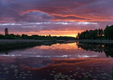 Arka planda gölün yansımaları olan güzel bir gün batımı. Gücün, enerjinin, barışın, uyumun ve sessizliğin harika yeri.