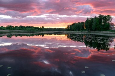 Arka planda gölün yansımaları olan güzel bir gün batımı. Gücün, enerjinin, barışın, uyumun ve sessizliğin harika yeri.