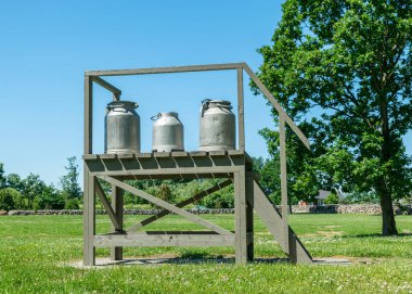 Tahta ahşap bir yapısı ve süt sürahisi olan güzel bir yaz manzarası, Saaremaa Adası, Estonya