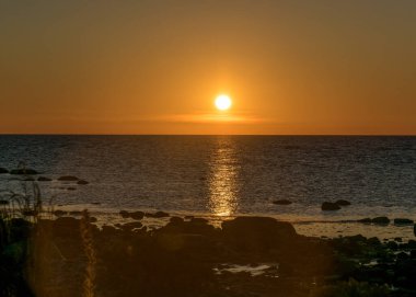 Saaremaa, Undva Burnu, Tagamoisa Yarımadası, Saaremaa Adası, Estonya 'daki geleneksel kayalık bir plajdan güzel bir gün batımı manzarası.