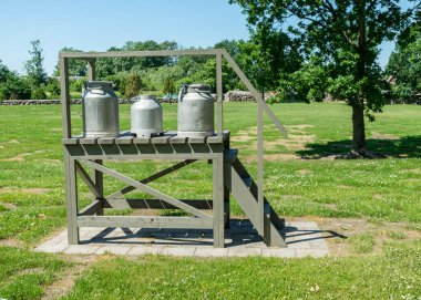 Tahta ahşap bir yapısı ve süt sürahisi olan güzel bir yaz manzarası, Saaremaa Adası, Estonya
