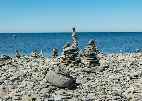 picture with beautiful white stone piles by the sea, these objects were built by travelers, Saaremaa Island, Estonia