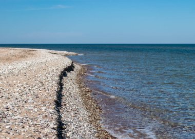 Geleneksel güneşli yaz manzarası kumlu ve çakıl taşlı, mavi deniz ve gökyüzü, Harilaid Doğa Rezervi, Estonya, Baltık Denizi