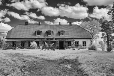 Kızılötesi gerçeküstü manzara, eski evler, karlı ağacın inanılmaz doğasının kızılötesi fotoğrafı.