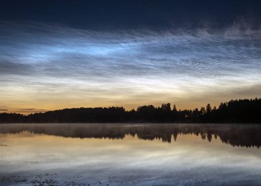 Gölü kaplayan beyaz gümüş bulutlu güzel bir gece manzarası bulanık bir ön plan göl suyunda büyüleyici bulut yansımaları, yaz gecesi