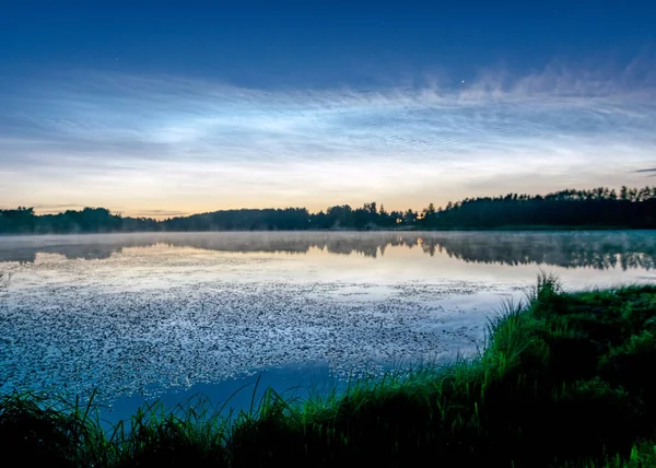 湖の上に白い銀の雲と美しい夜の風景 ぼやけた前景 湖の水の中に魅力的な雲の反射 夏の夜 — ストック写真