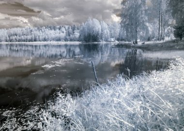 Kızılötesi filtreyle çekilen soyut manzara, kışın ağaçlar gibi görünür, suda güzel bulut yansımaları, gerçeküstü manzara.