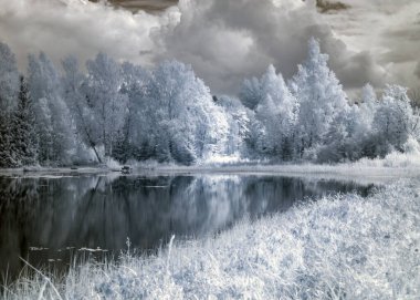 Kızılötesi filtreyle çekilen soyut manzara, kışın ağaçlar gibi görünür, suda güzel bulut yansımaları, gerçeküstü manzara.