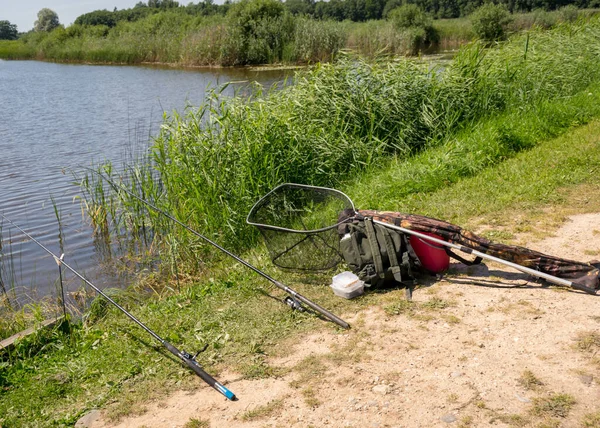 Słoneczny Letni Krajobraz Nad Jeziorem Sprzęt Wędkarski Pierwszym Planie Spokojna — Zdjęcie stockowe