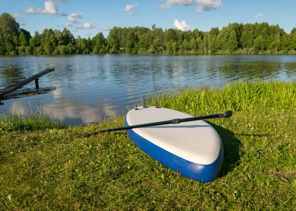 阳光明媚的夏季风景 在前边的冲浪板上 绿色的湖岸 — 图库照片