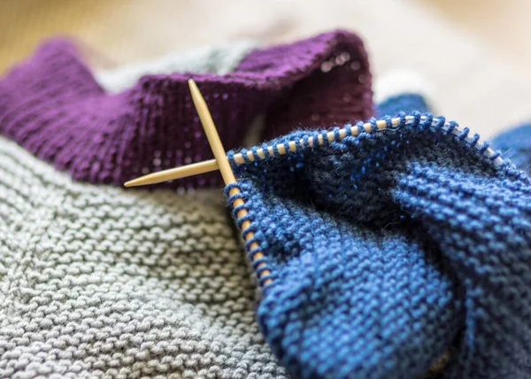picture with knitted sweater, knitting needles and yarn, close-up view