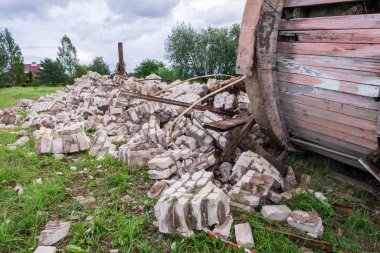 Altını üstüne getirilmiş eski su kulesi, yerde ahşap varil, beyaz tuğla kalıntıları, Letonya, Vaidava 20.22.07