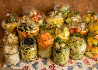 Çeşitli sebzelerle dolu cam kavanozlar, konserve sebzeler, uzun vadeli depolama için cam kavanozlarda çeşitli sebzeler, çeşitli mayalanmış yeşil sebzeler.